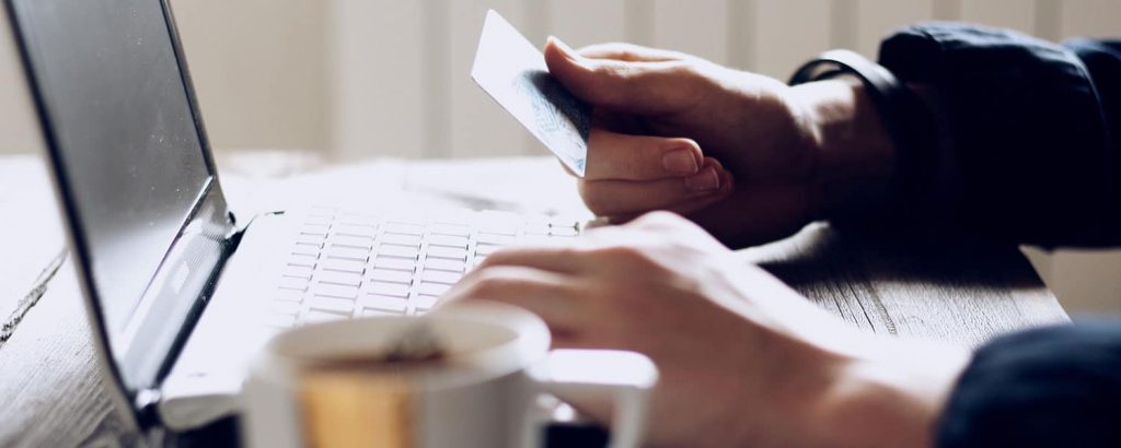 Facebook Shopping for Business | How to Run Facebook Shopping | Man Holding Credit Card at Laptop