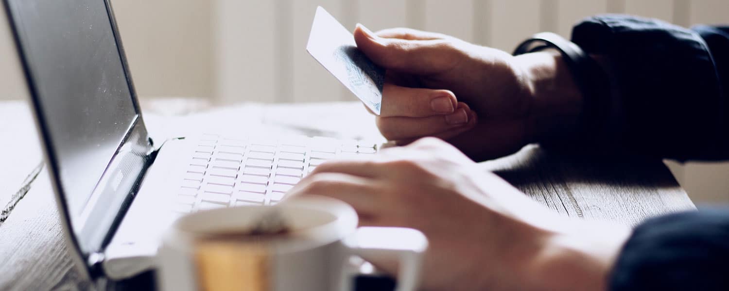 Facebook Shopping for Business | How to Run Facebook Shopping | Man Holding Credit Card at Laptop